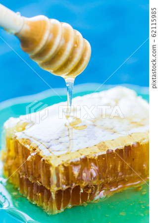 Honey with wooden honey dipper and honeycombs Honey with wooden honey dipper and honeycombs 62115985