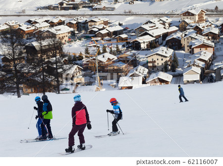 Skiers and snowboarder on snowy ski slope in high Skiers and snowboarder on snowy ski slope in high 62116007