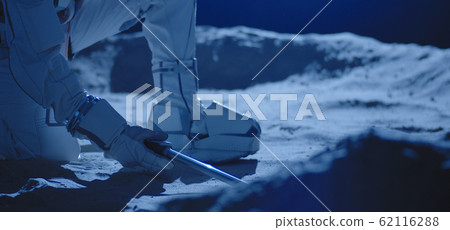 Astronaut using equipment to collect samples Astronaut using equipment to collect samples 62116288