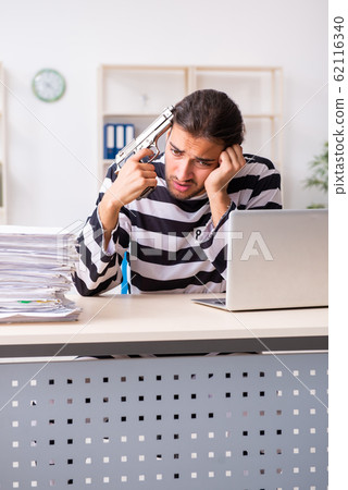 Young employee feeling like prisoner at work Young employee feeling like prisoner at work 62116340