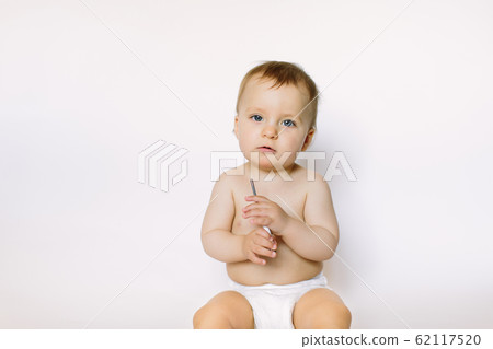 A baby girl uses a digital thermometer, holds it in her hands on a white background A baby girl uses a digital thermometer, holds it in her hands on a white background 62117520