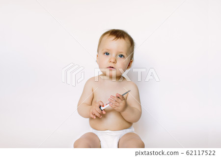 A baby girl uses a thermometer, holds it in her hands on a white background A baby girl uses a thermometer, holds it in her hands on a white background 62117522