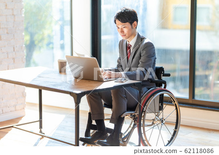 Business man in wheelchair using a computer 62118086