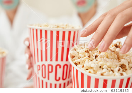 Selective focus of popcorn boxes in female arms. Selective focus of popcorn boxes in female arms. 62119385