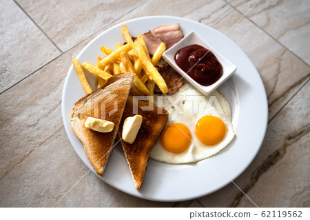 Fried eggs with toast and french fries for breakfast Fried eggs with toast and french fries for breakfast 62119562