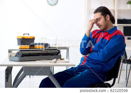 Young repairman repairing air-conditioner at warranty center Young repairman repairing air-conditioner at warranty center 62120506
