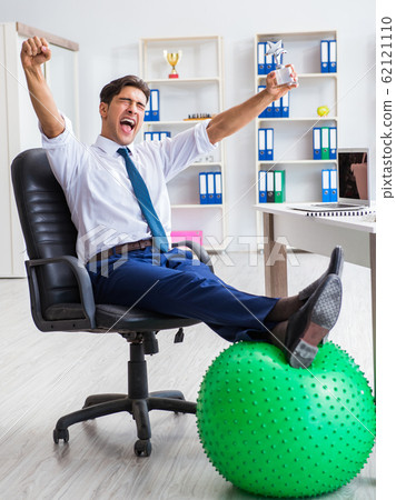 Young businessman doing sports stretching at workplace Young businessman doing sports stretching at workplace 62121110