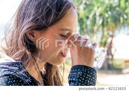 Tween girl drinks glass of water 62121633