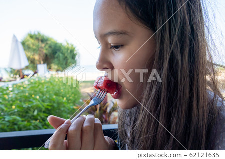 Tween girl eats watermelon with a fork 62121635