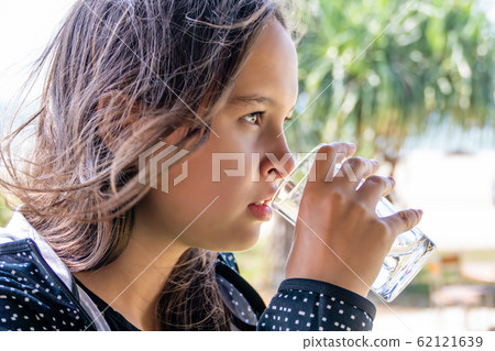Tween girl drinks glass of water 62121639