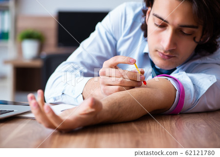 Young man having problems with narcotics at workplace 62121780