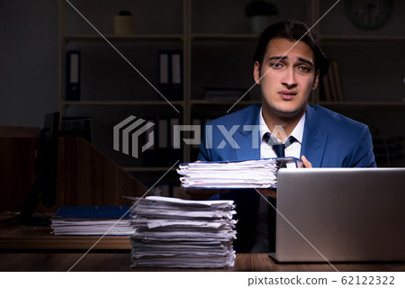 Young male employee working night in the office Young male employee working night in the office 62122322