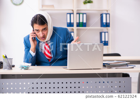 Young male employee suffering in the office Young male employee suffering in the office 62122324