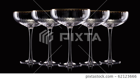 Set of empty luxury champagne glasses in a row isolated on a black background Set of empty luxury champagne glasses in a row isolated on a black background 62123666