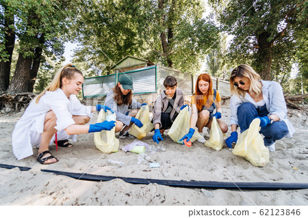 Group of activists friends collecting plastic waste on the beach. Environmental conservation. Group of activists friends collecting plastic waste on the beach. Environmental conservation. 62123846