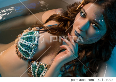 Woman in mermaid image lying in bath shot Woman in mermaid image lying in bath shot 62124098