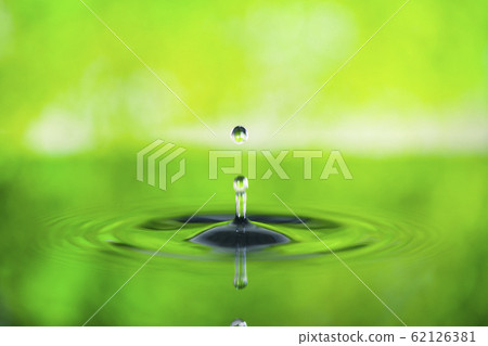 Fresh green background with drops falling on water surface 62126381