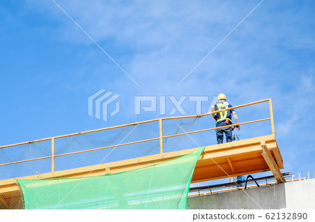 Engineer working on high ground construction site. Wear a helmet safety and uniform staff 62132890