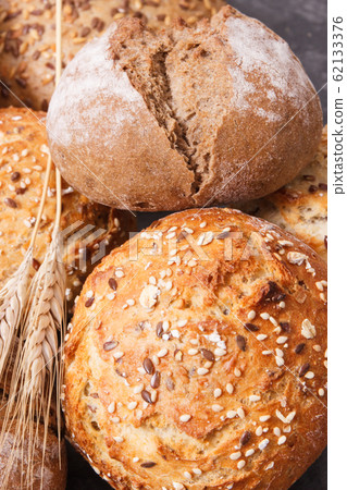 Fresh baked rolls with seeds and ears of rye 62133376