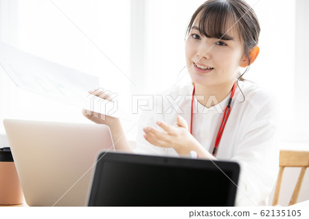 Business scene: a young female office worker operating a personal computer Business scene: a young female office worker operating a personal computer 62135105