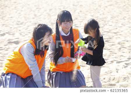 High school students and parents and children playing with children High school students and parents and children playing with children 62135365