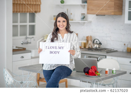 Dark-haired woman in a striped blouse smiling nicely 62137020