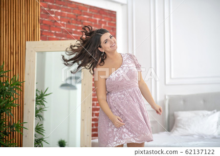 Young plus-size woman waving her hair and feeling wonderful Young plus-size woman waving her hair and feeling wonderful 62137122
