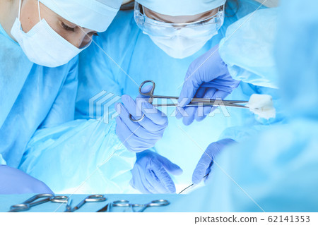 Close-up of medical team performing operation. Group of surgeons at work are busy of patient. Medicine, veterinary or healthcare and emergency in hospital 62141353