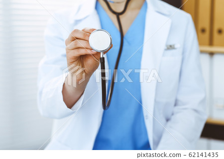 Unknown doctor woman holds stethoscope head, close-up. Physician ready to examine and help patient. Helping and insurance in health care, best treatment and medicine concept 62141435