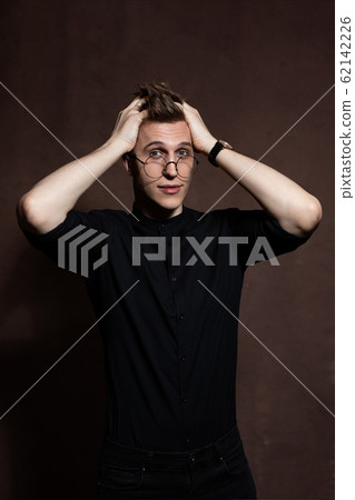 Man in round glasses and a black shirt. Man in round glasses and a black shirt. 62142226