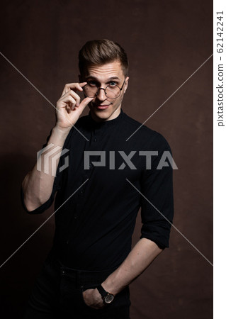 Man in round glasses and a black shirt. Man in round glasses and a black shirt. 62142241