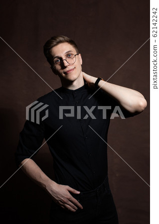 Man in round glasses and a black shirt. Man in round glasses and a black shirt. 62142242