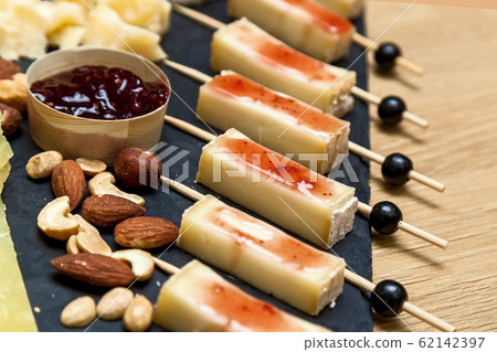 A cheese cutting from different types of cheese on A cheese cutting from different types of cheese on 62142397