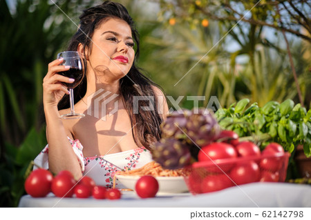 Italian Woman in summer dress eats Italy spaghetti Italian Woman in summer dress eats Italy spaghetti 62142798