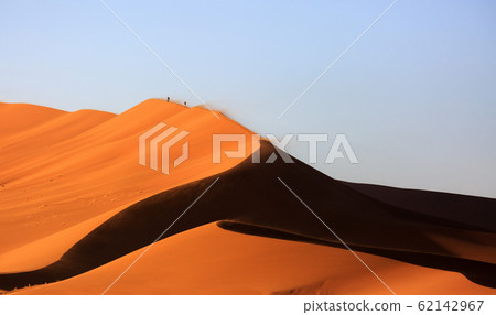 Beautiful landscape with red huge sand dunes at sunset in desert. Sossusvlei, Namib Naukluft National Park, Namibia. Stunning natural geometry without people 62142967