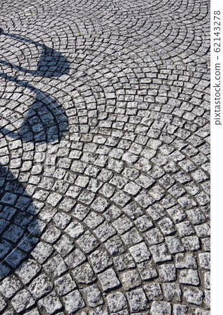 Bollard shadow on a stone pavement 62143278