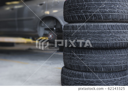 Car tire replace in garage, old tyre wheel service 62143325