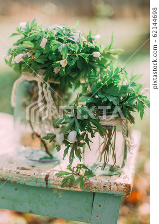 Bouquet of white spring flowers in Glass Jar On wooden chair in the forest outdoors Bouquet of white spring flowers in Glass Jar On wooden chair in the forest outdoors 62144698