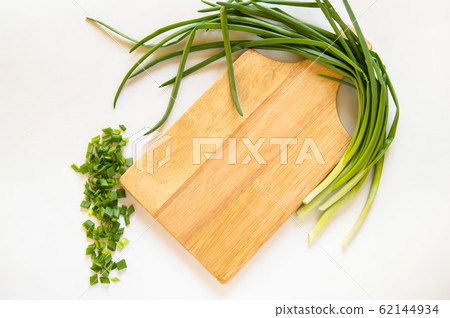 Flat lay green onion feather and sliced pieces on cutting wooden Board isolated on white background, organic food concept, copy space Flat lay green onion feather and sliced pieces on cutting wooden Board isolated on white background, organic food concept, copy space 62144934