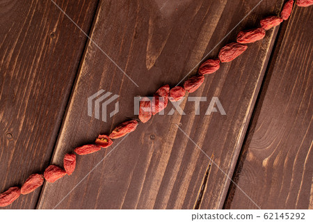 Red dried goji on brown wood Red dried goji on brown wood 62145292