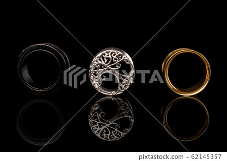 Stylish ear plug isolated on black glass Stylish ear plug isolated on black glass 62145357