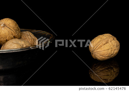 Brown tasty walnut isolated on black glass Brown tasty walnut isolated on black glass 62145476