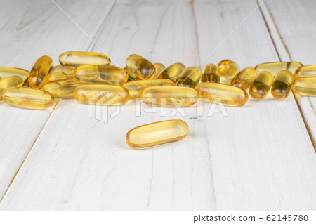 Golden fish oil on grey wood 62145780