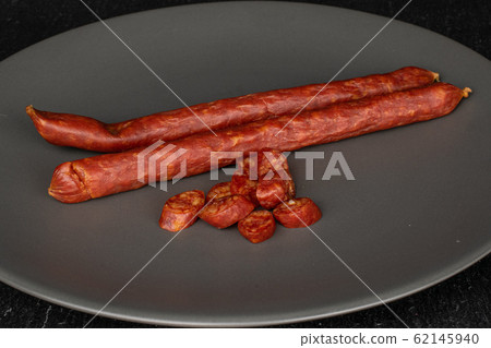 Smoked spicy sausage on grey stone 62145940