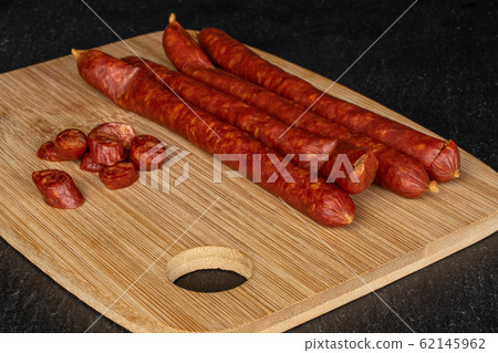 Smoked spicy sausage on grey stone Smoked spicy sausage on grey stone 62145962