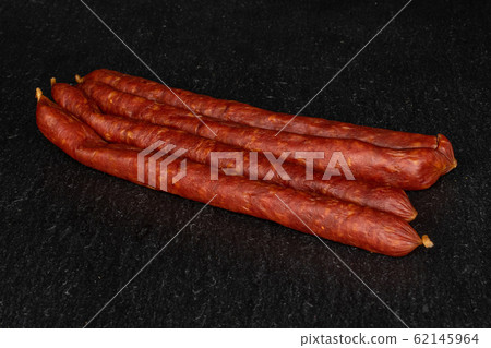 Smoked spicy sausage on grey stone 62145964
