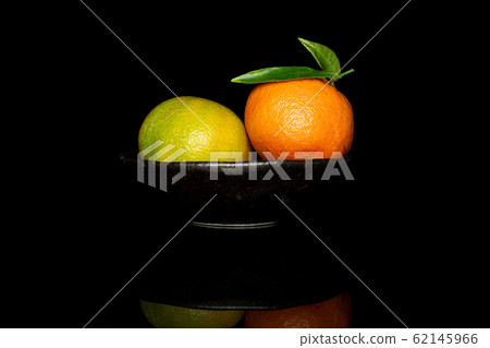Fresh orange mandarin isolated on black glass Fresh orange mandarin isolated on black glass 62145966