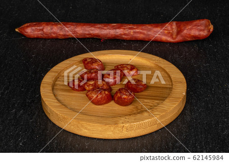 Smoked spicy sausage on grey stone Smoked spicy sausage on grey stone 62145984