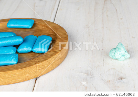 Blue chewing gum on grey wood Blue chewing gum on grey wood 62146008