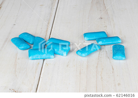 Blue chewing gum on grey wood Blue chewing gum on grey wood 62146016